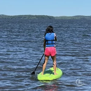 A girl is riding SUP at Adventure Bay Cottage