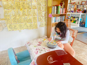 A girl is doing diy arts and craft in playing room at Adventure Bay Cottages Canada